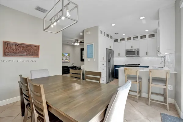 a dining room with furniture a chandelier and wooden floor