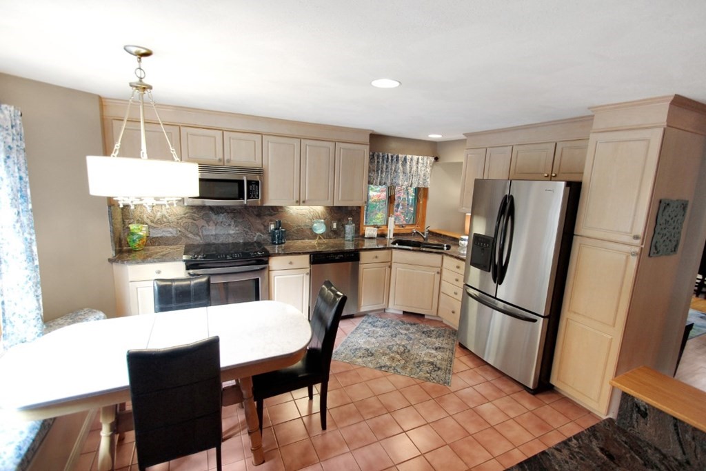 6 Patterson Road Shirley, MA 01464 - Photo 9 of 27 a kitchen with stainless steel appliances a refrigerator a stove a sink a dining table and chairs