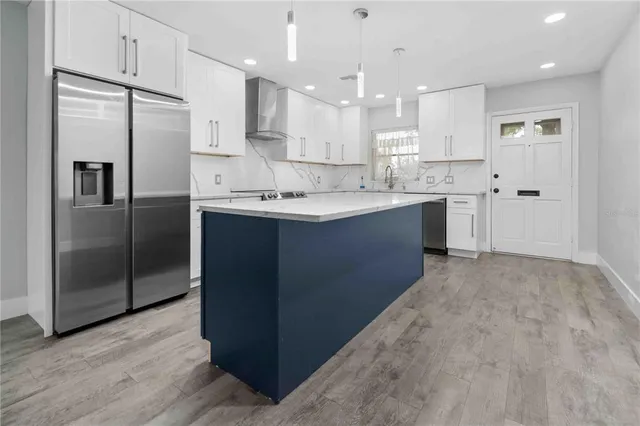 a kitchen with stainless steel appliances granite countertop a refrigerator and a sink