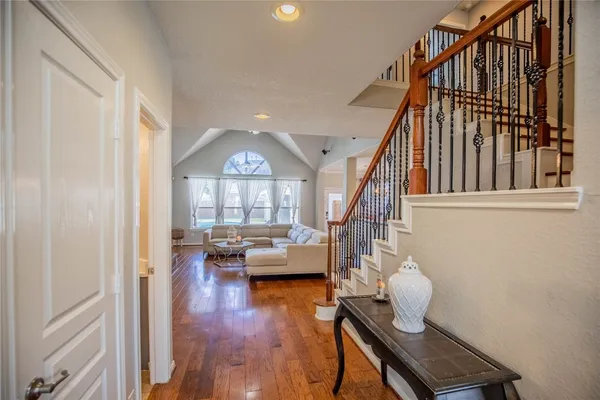 a living room with couches and a bookshelf with wooden floor