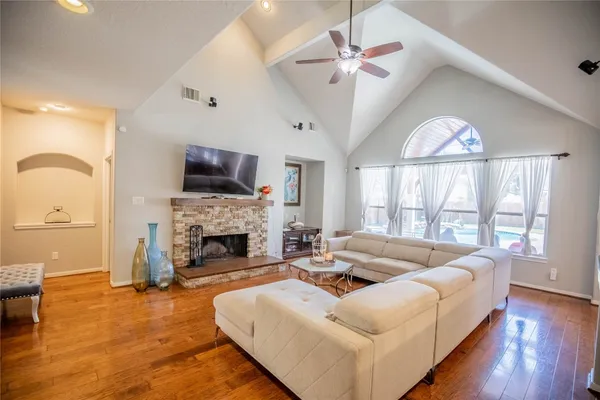 a living room with furniture fireplace and a large window