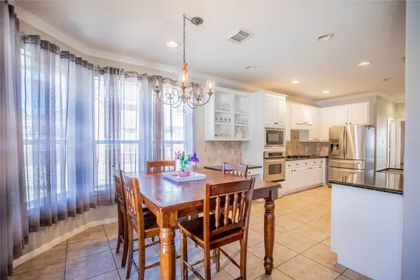 a view of a dining room and livingroom with furniture wooden floor a chandelier