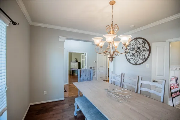 a view of a dining room with furniture a chandelier and wooden floor