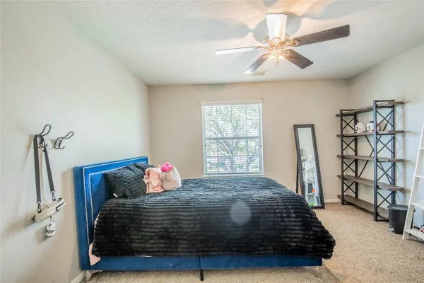 a bedroom with a bed and ceiling fan
