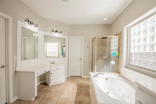 a spacious bathroom with a tub sink and mirror