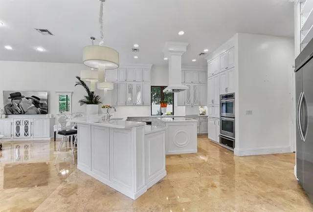 a kitchen with a sink stainless steel appliances a counter space and a window