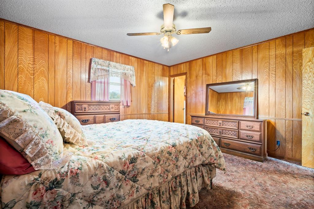 596 North FM 129 Santo, TX 76472 - Photo 19 of 40 a bedroom with a bed and a chandelier