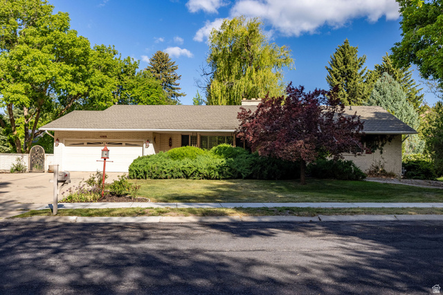 1365 Sumac Drive Logan, UT 84321 - Photo 1 of 66 Ranch-style exterior with a two-car garage, mature landscaping, and a paved driveway