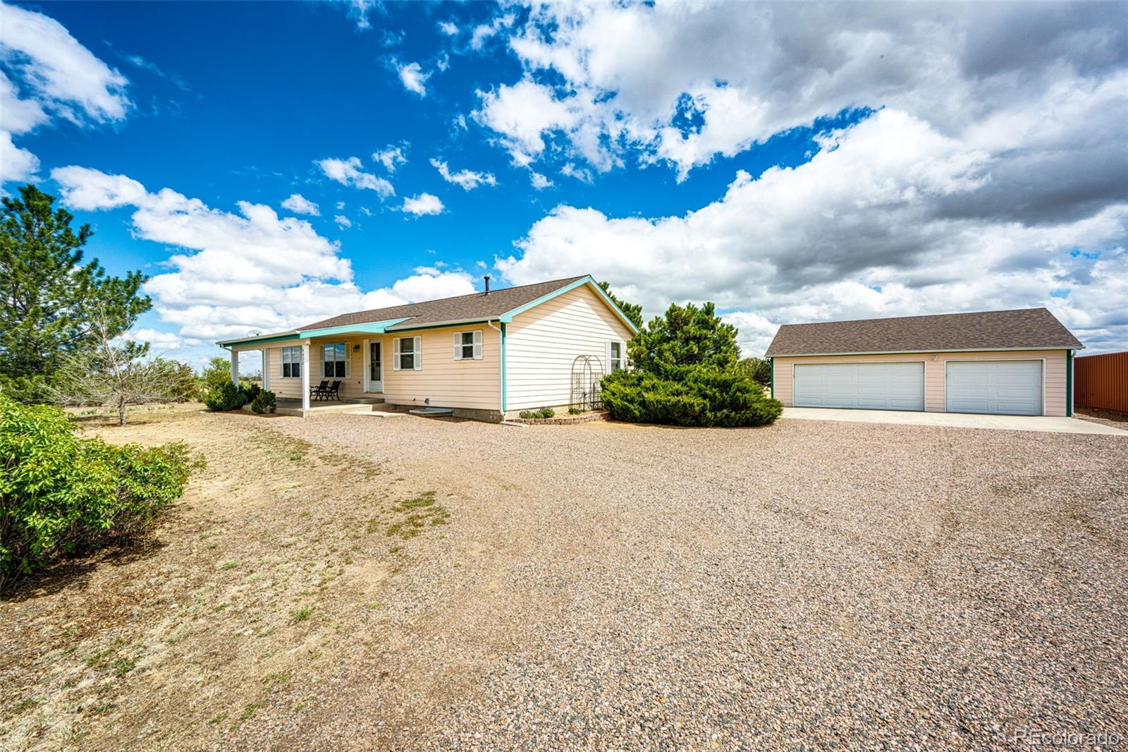 4420 Behrens Road Byers, CO 80103 - Photo 2 of 39 a front view of a house with a yard and garage