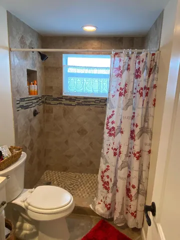 a bathroom with a toilet and a shower curtain