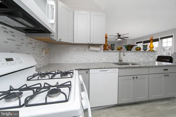 a kitchen with stainless steel appliances granite countertop a sink stove and cabinets