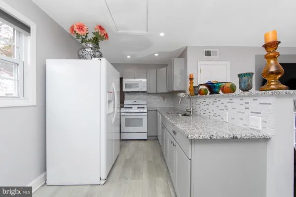 a kitchen with a refrigerator and a white cabinets