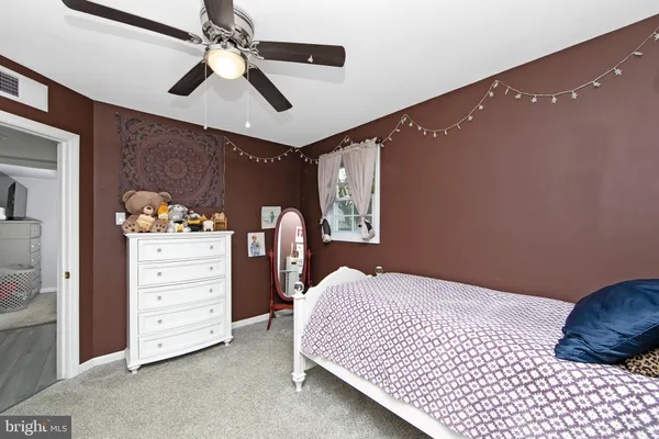 a bedroom with a bed and a ceiling fan
