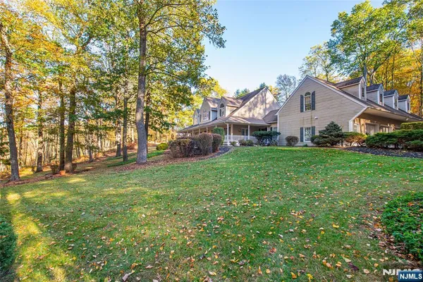 a front view of a house with a yard and trees