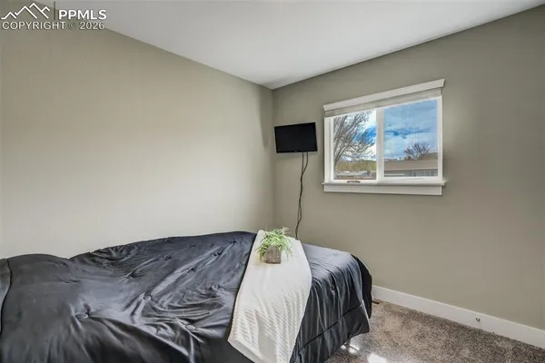 a bedroom with a bed and a painting on the wall