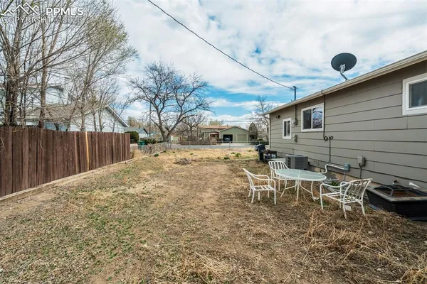a backyard of a house with table and chairs