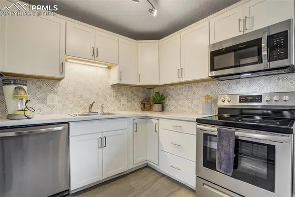 a kitchen with cabinets stainless steel appliances and sink