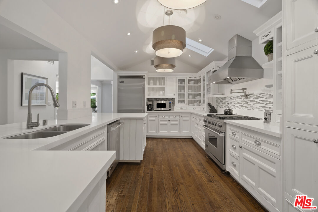 2761 Hutton Drive Beverly Hills, CA 90210 - Photo 13 of 29 a large kitchen with stainless steel appliances kitchen island a large counter space a sink and cabinets