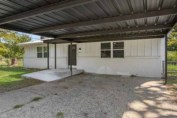 a front view of a house with a garden and yard
