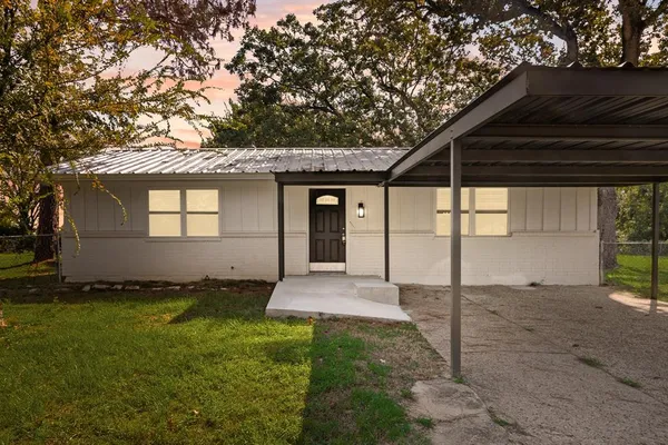 a view of a house with backyard and a tree