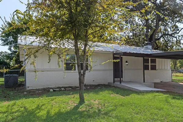 a view of a house with backyard and a tree