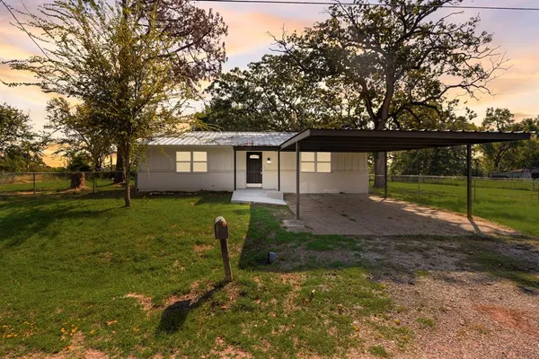 a view of a house with backyard and a tree