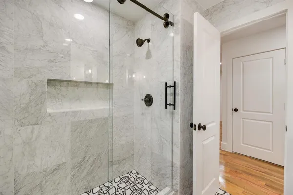 a bathroom with a sink a toilet a mirror and shower