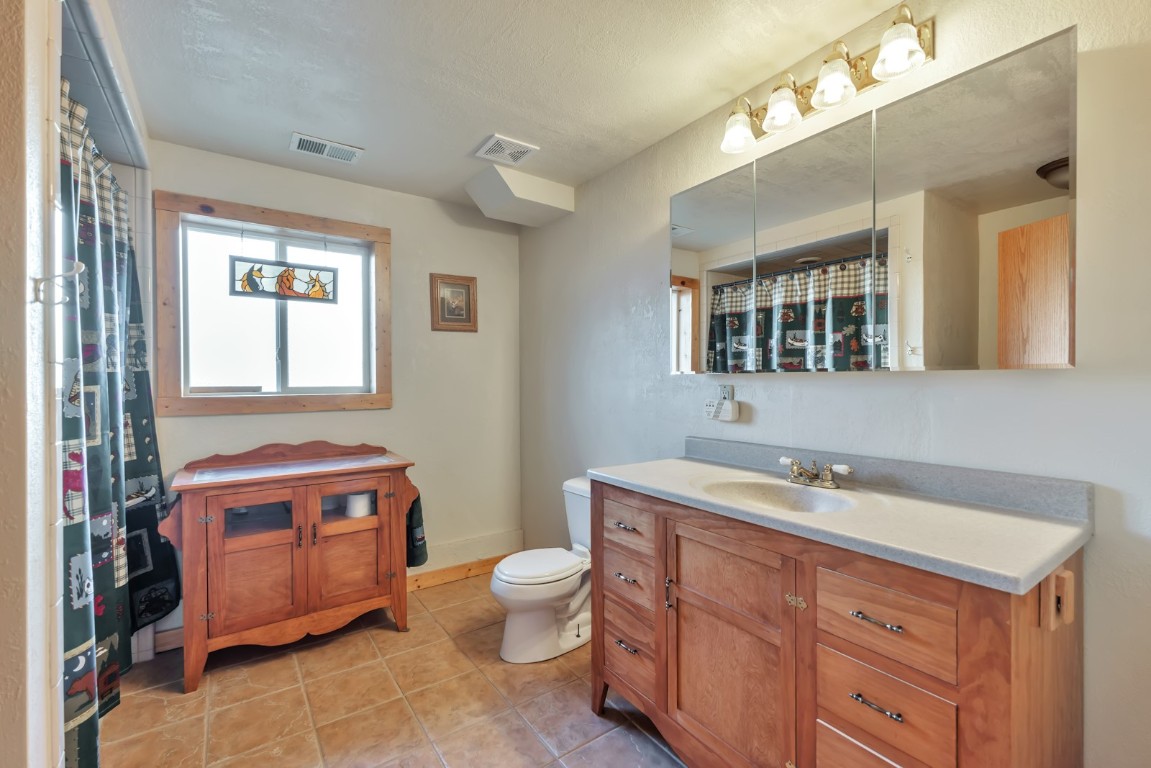 64 Flint Circle Como, CO 80456 - Photo 28 of 35 a spacious bathroom with a double vanity sink a mirror and a toilet