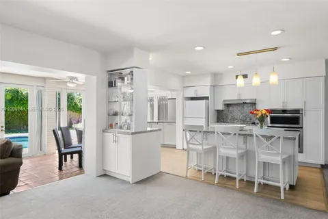 a kitchen with stainless steel appliances kitchen island granite countertop a table and chairs
