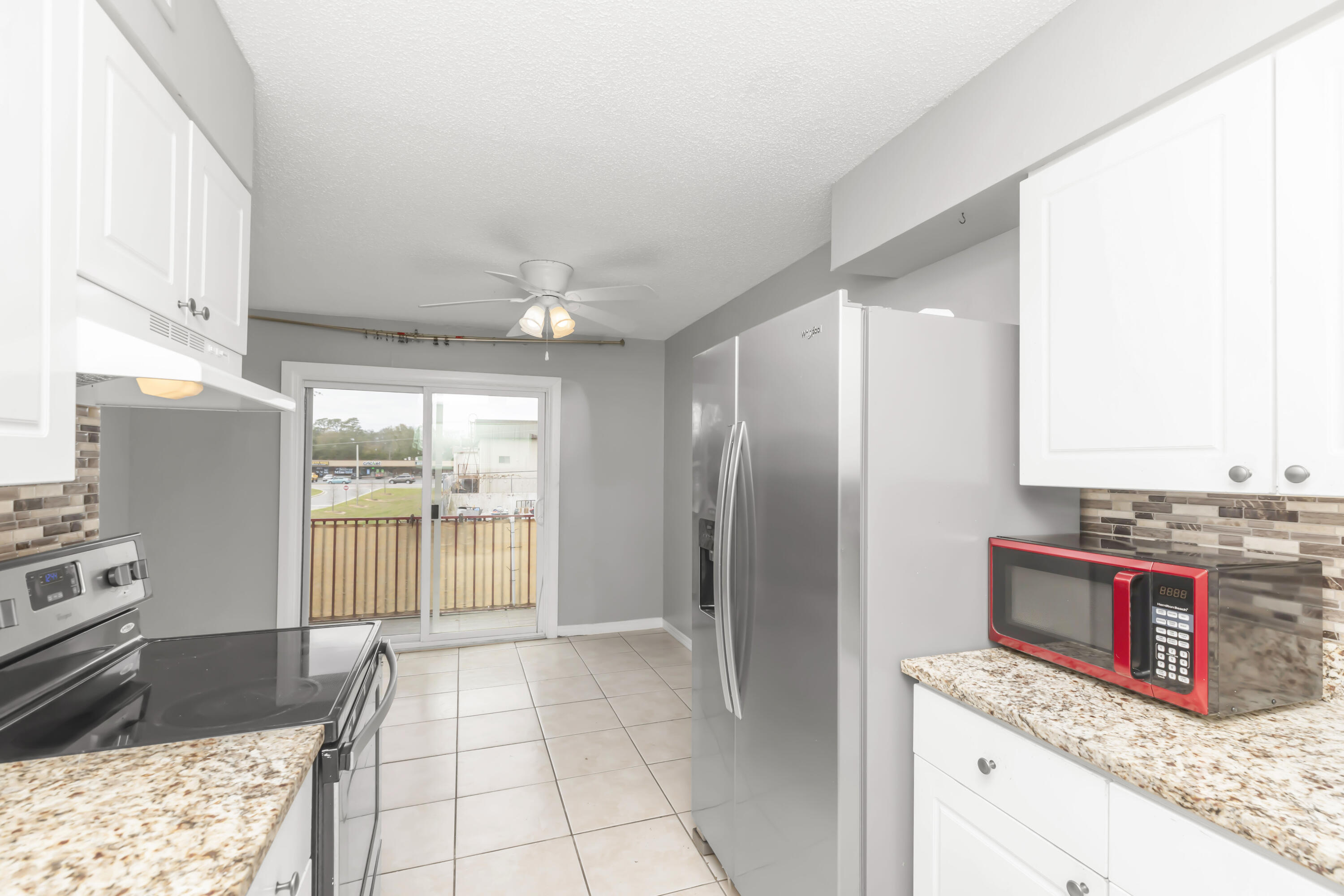 210 Pelham Road, Unit 219A Fort Walton Beach, FL 32547 - Photo 13 of 34 a kitchen with stainless steel appliances granite countertop a refrigerator a stove and a sink with granite countertops