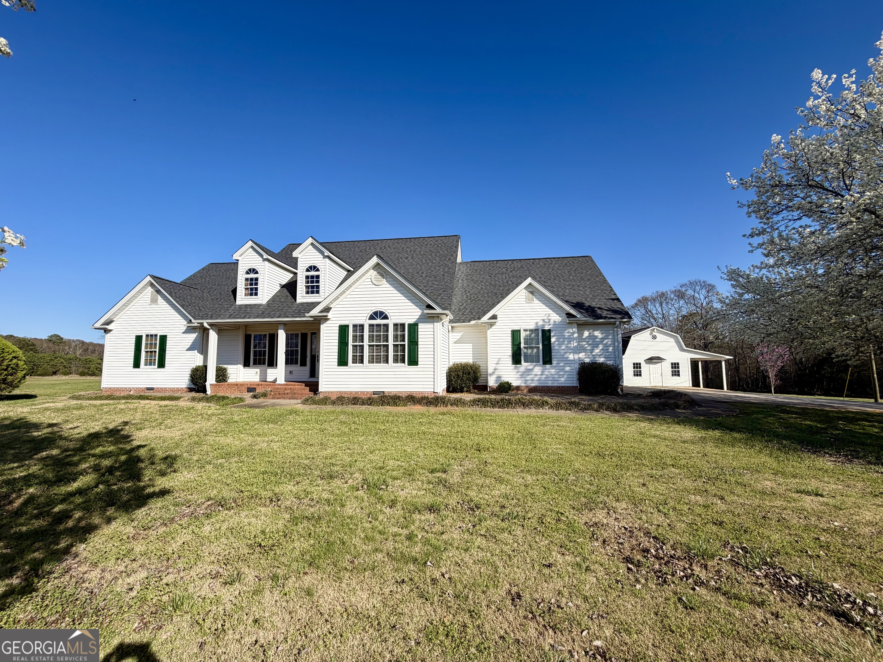 494 Broad Street Bowman, GA 30624 - Photo 5 of 65 a front view of a house with a garden and deck