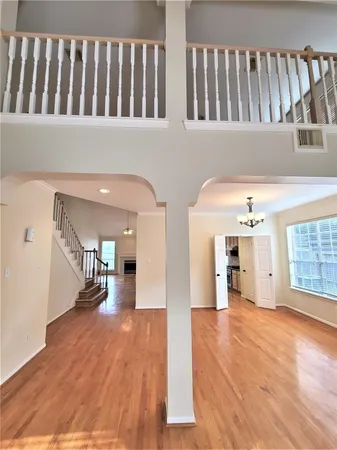 a hallway with wooden floor and a living room