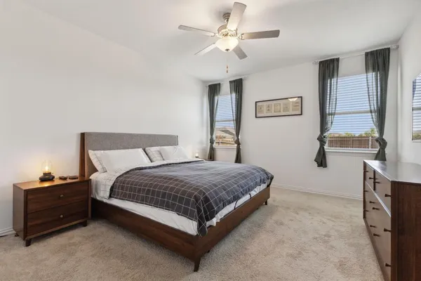 a spacious bedroom with a bed and a chandelier