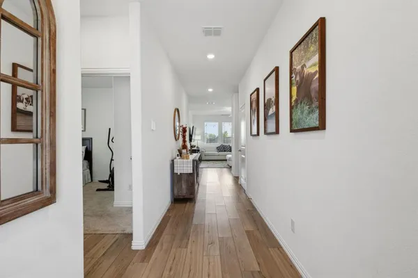 a view of a hallway with wooden floor and staircase