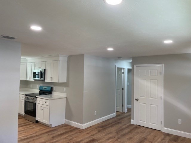 73 Cairn Road Brockton, MA 02302 - Photo 3 of 10 a kitchen with white cabinets and wooden floor
