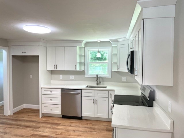73 Cairn Road Brockton, MA 02302 - Photo 10 of 10 a kitchen with a sink a stove a refrigerator and white cabinets