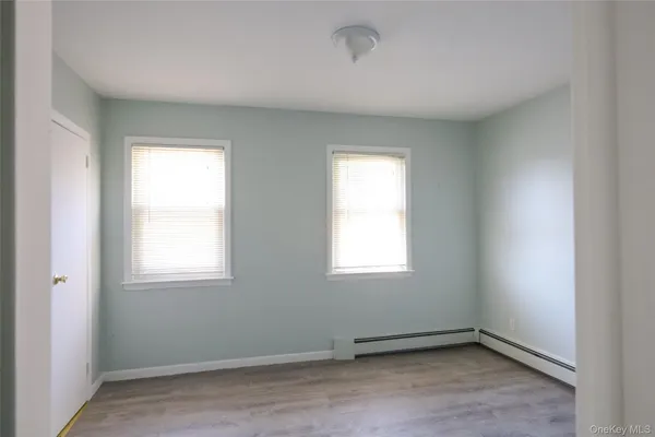 an empty room with windows and closet
