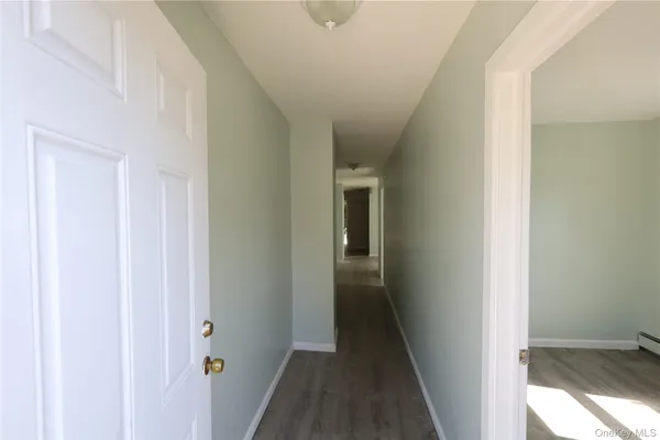 a view of a hallway with wooden floor and entryway