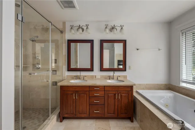 a bathroom with a granite countertop double vanity sink mirror and double