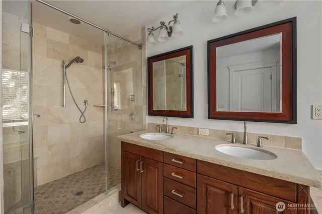 a bathroom with double vanity sinks and a shower