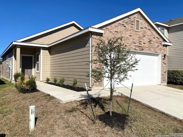 a view of a house with backyard and sitting area