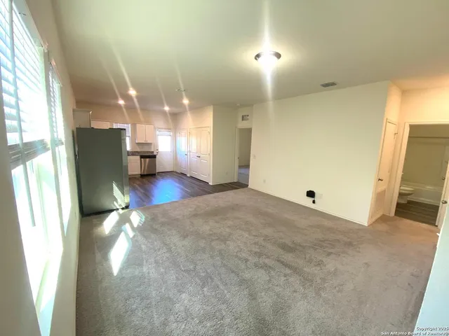 a view of a kitchen with a refrigerator cabinets and a wooden floor