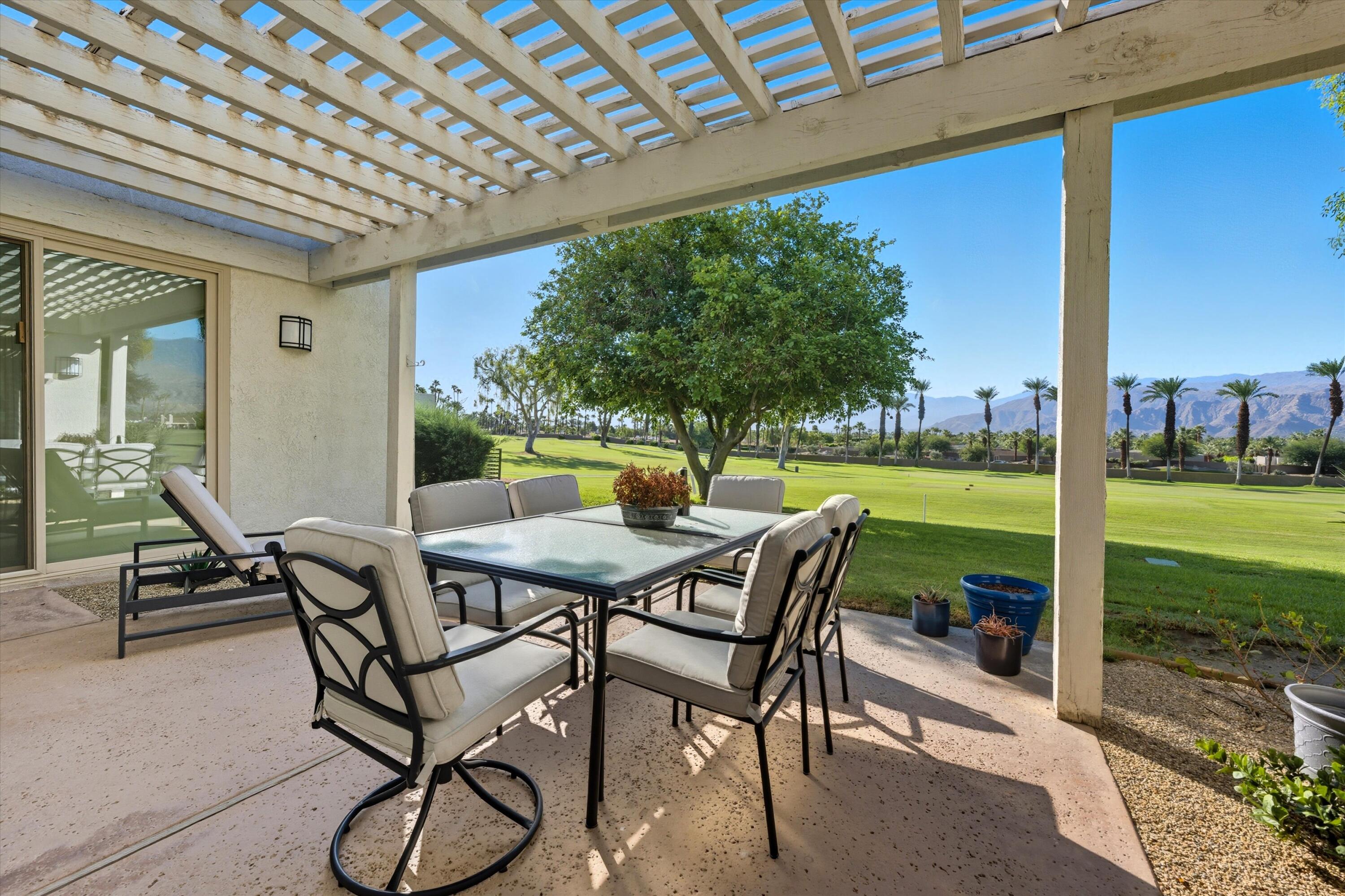 809 Inverness Drive Rancho Mirage, CA 92270 - Photo 11 of 36 a view of a patio with a table chairs and a backyard
