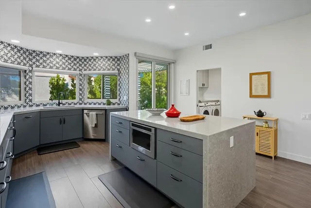 a kitchen that has a lot of cabinets in it and wooden floor