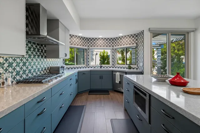 a kitchen with stainless steel appliances a sink dishwasher and wooden cabinets