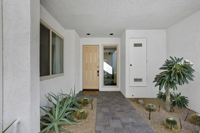 a view of a entryway door with potted plants
