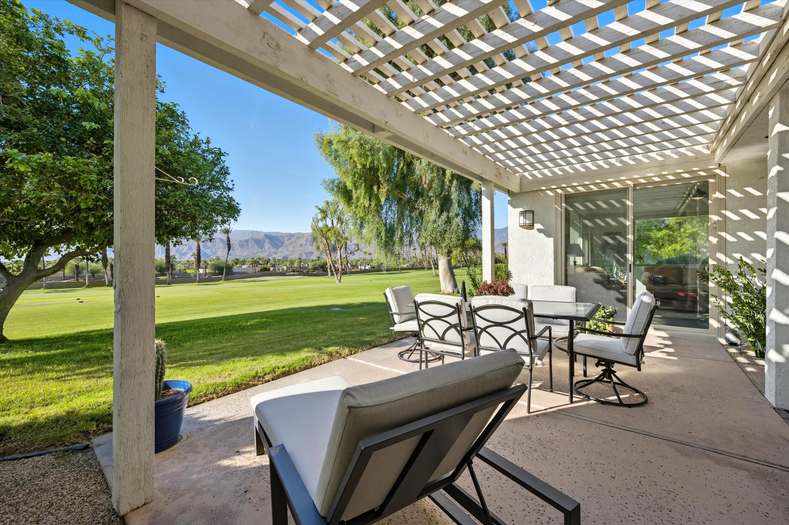 809 Inverness Drive Rancho Mirage, CA 92270 - Photo 10 of 36 a view of a patio with table and chairs with plants and garden view