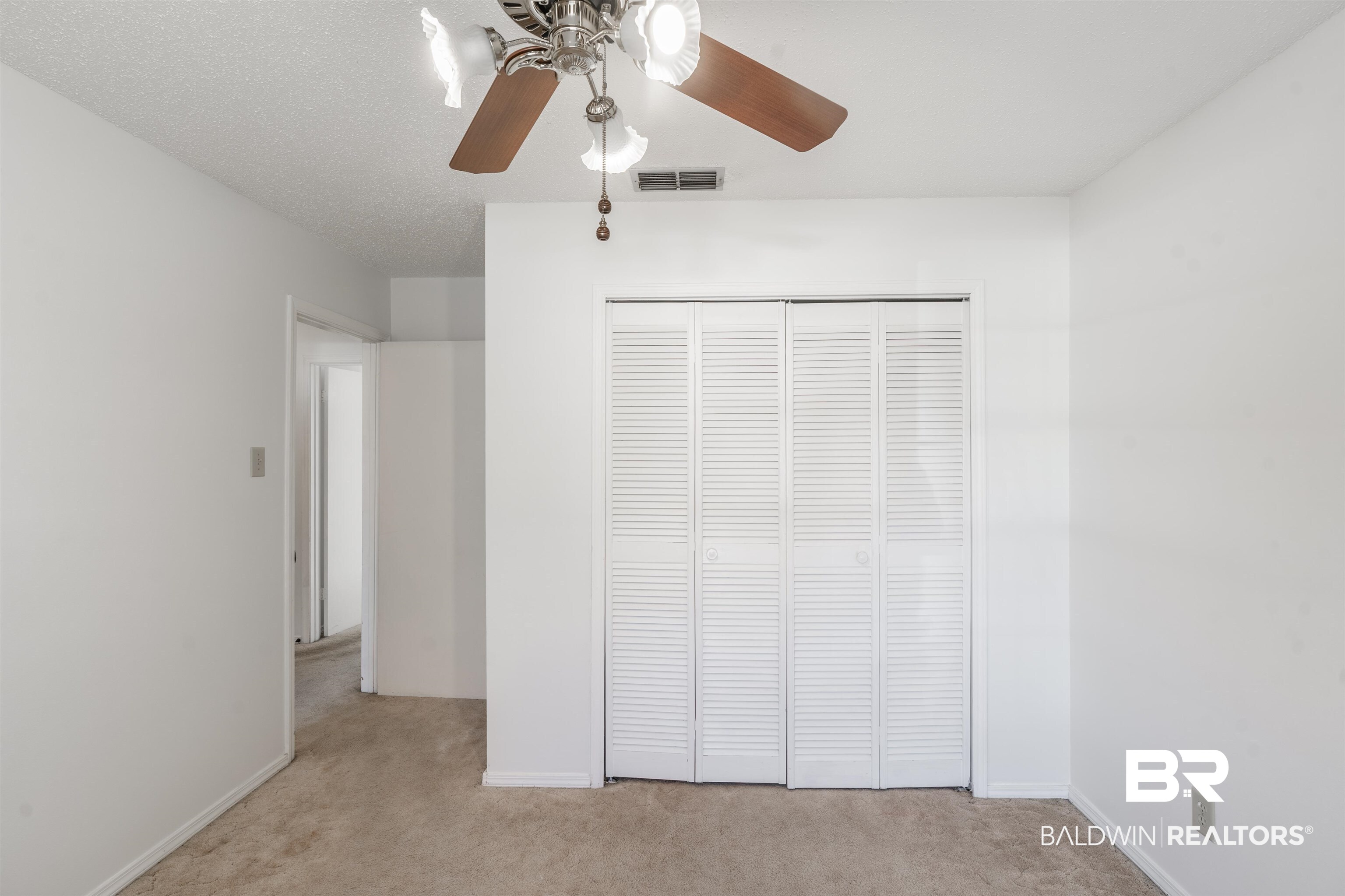 9751 Pine Knoll Road Mobile, AL 36608 - Photo 18 of 36 Unfurnished bedroom featuring light colored carpet, a ceiling fan, and a closet