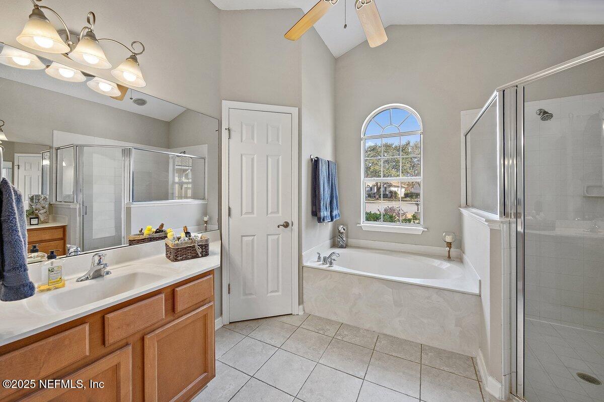 2045 River's Own Road St. Augustine, FL 32092 - Photo 14 of 43 a spacious bathroom with a double vanity sink a mirror a bathtub and next to a window