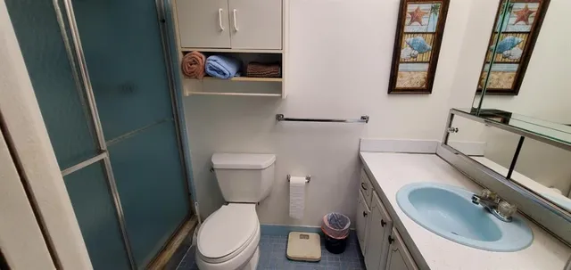 a white toilet sitting next to a sink and a mirror